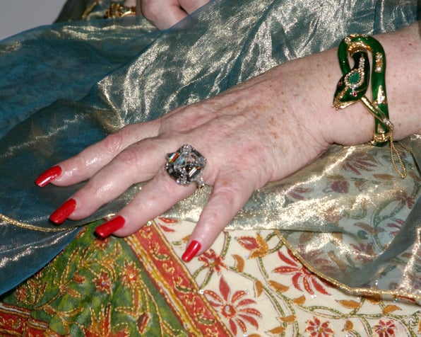  A close up of Elizabeth Taylor's engagement ring on her hand. 