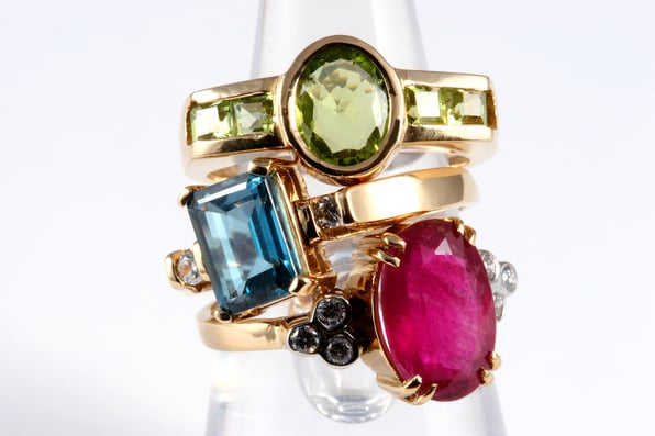  A stack of four dress rings with various birthstones. 