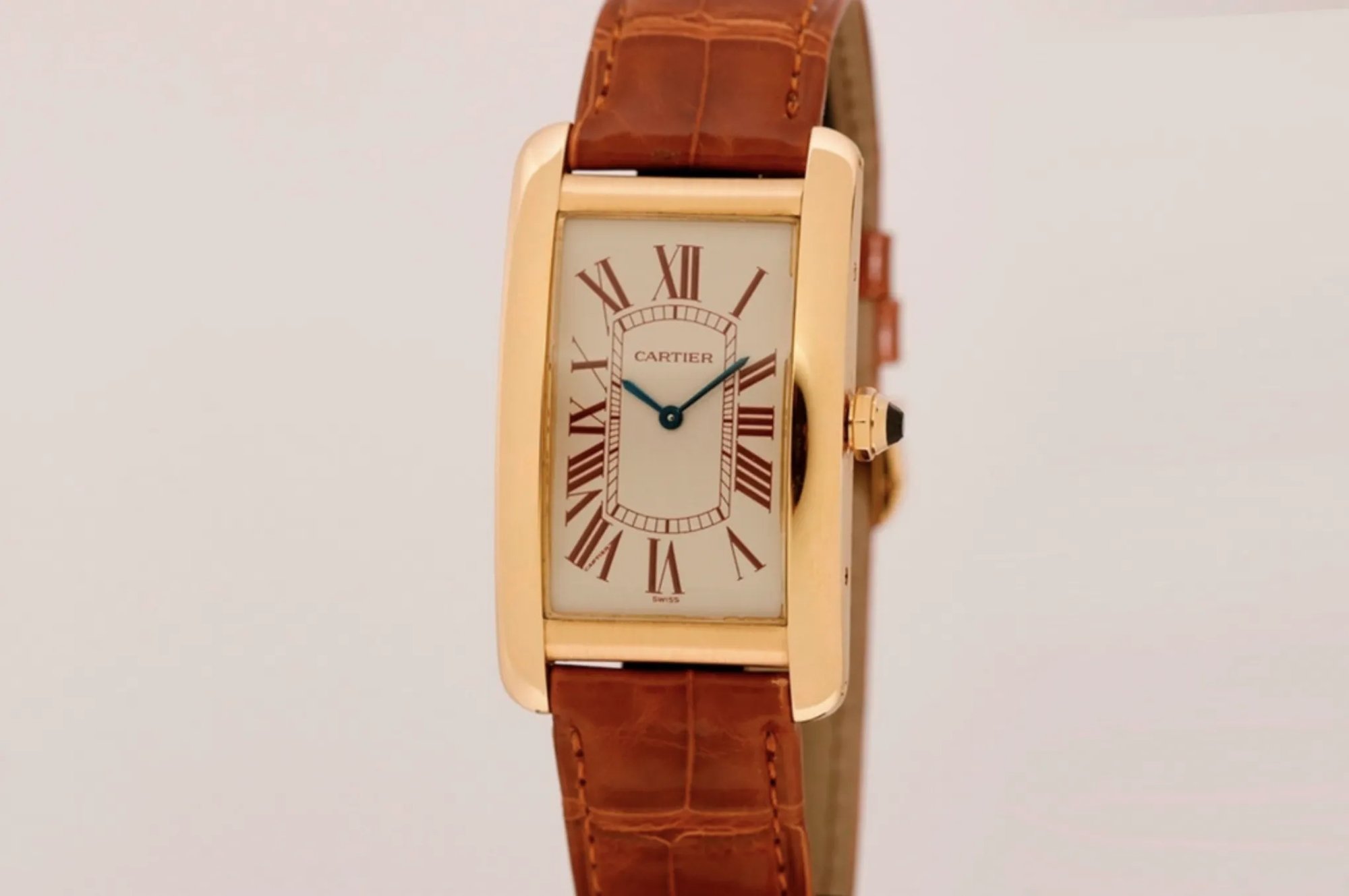 A Cartier Tank with brown leather strap.